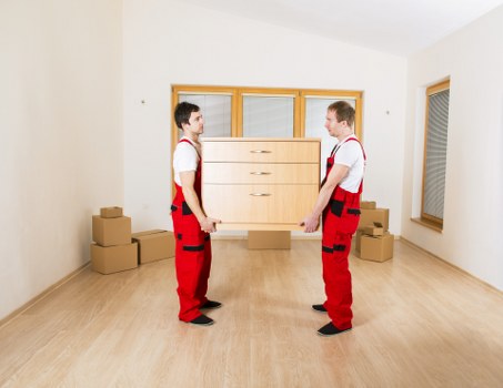 Professional movers carrying items from a residential property